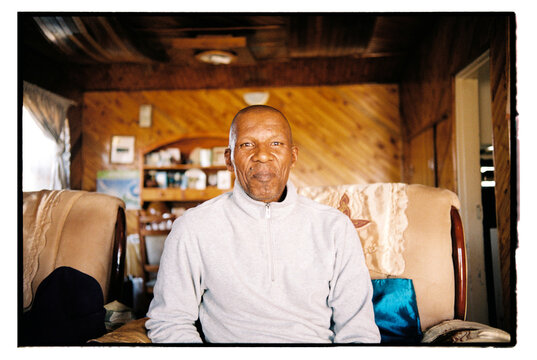 60 year old man sitting on a sofa in his home
