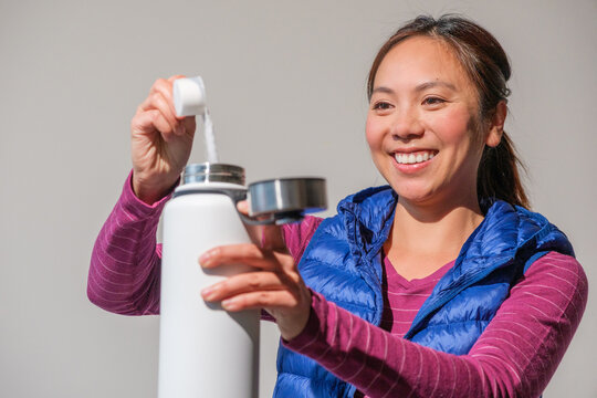 woman with water bottle and electrolyte powder