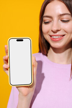 Woman Holding Phone with Blank White Screen Yellow Background. Mockup