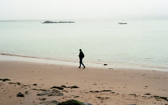 Man standing alone at the beach Saint Malo, France.