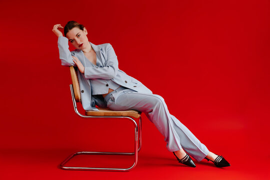 Businesswoman  sitting on chair with red background