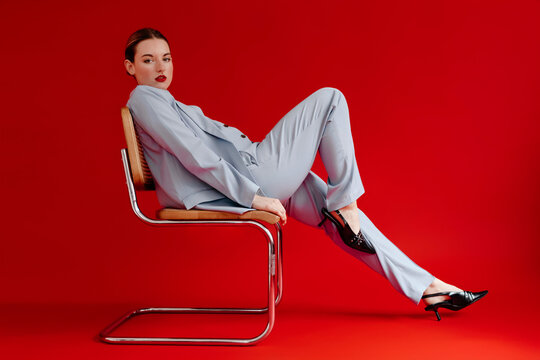 Woman wearing pastel blue suit sitting on chair