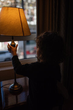 Little boy playing with a lamp