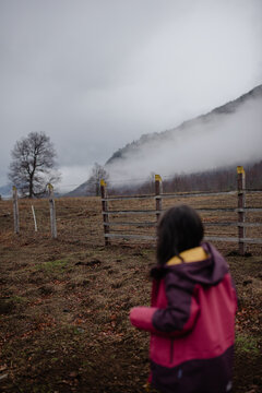 Girl with her back turned in a winter mountain landscape 