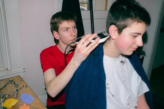 older bother giving his younger sibling a haircut 