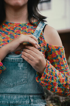 hands buttoning denim overalls
