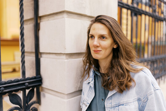 portrait of androgynous woman in front of the grey architecture 