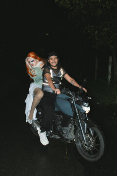 Drag queen on motorcycle with smiling man 