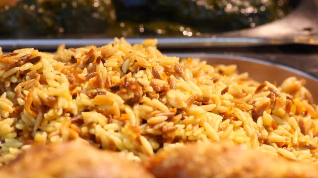 Close up of cooked orzo pasta with vermicelli and vegetables in a serving tray