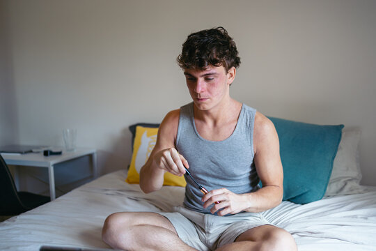 Young man doing his makeup at home