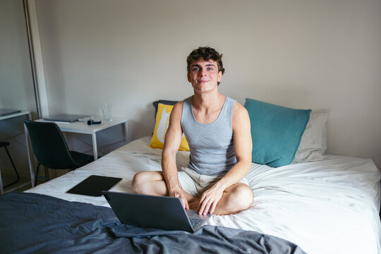 Cheerful man checking the mail in bed