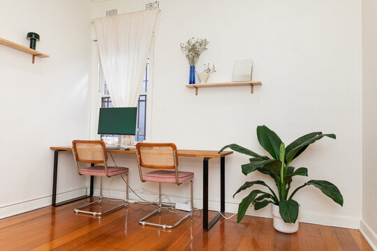 A coworking space with two chairs in front of a desk with a computer