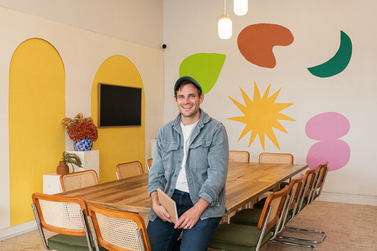 Smiling man seated at a large community table