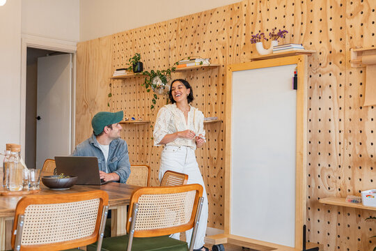 Two people having a conversation with a computer in a workspace
