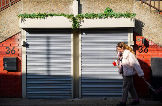A woman from side walking in the streets of Brixton, London 