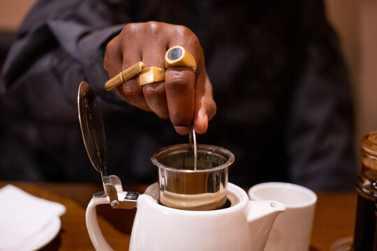 Black mans hand making tea