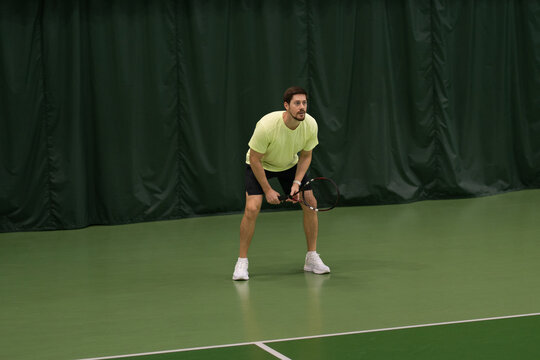 Tennis Player Ready to Receive Serve in Indoor Court
