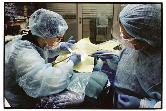 Dental Procedure with Two Dentists Working on Patient
