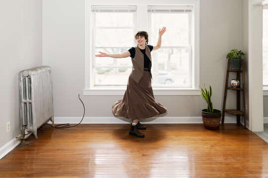 Young woman spinning gleefully in empty apartment
