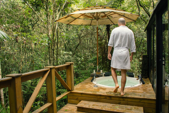 Man walking toward outdoor jacuzzi 