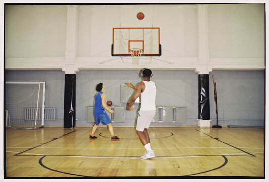 Basketball Players Shooting and Passing in Gym
