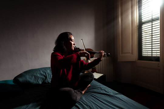Committed musician practicing on bed