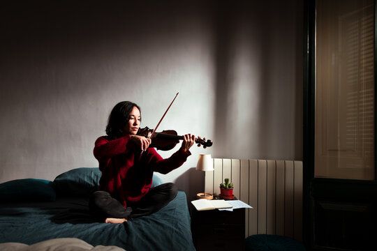 Focused violinist practicing effort at home