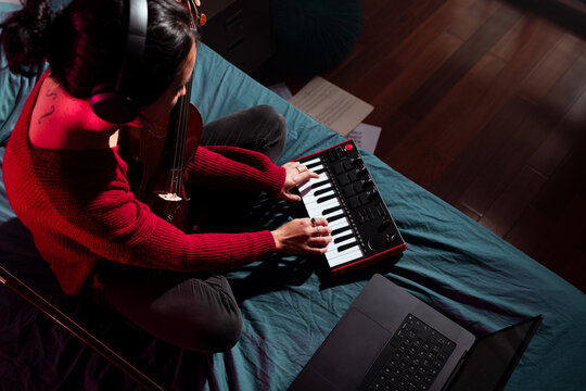 Musician playing music keyboard on bed