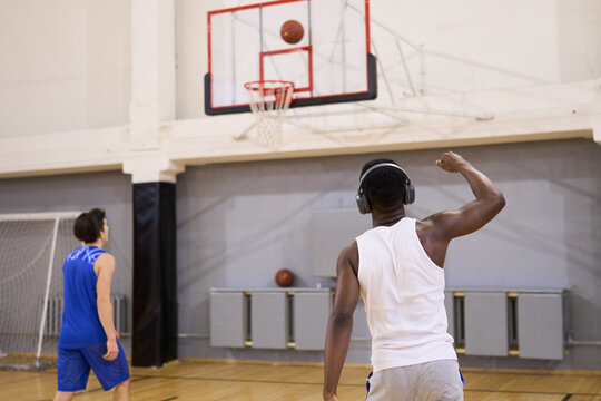Two Basketball Players Practicing in Gym with Basketballs
