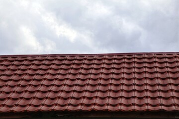 House roof with steel roofing sheet. metal shingle tiles. red modular tile effect roof panel. Building's covering