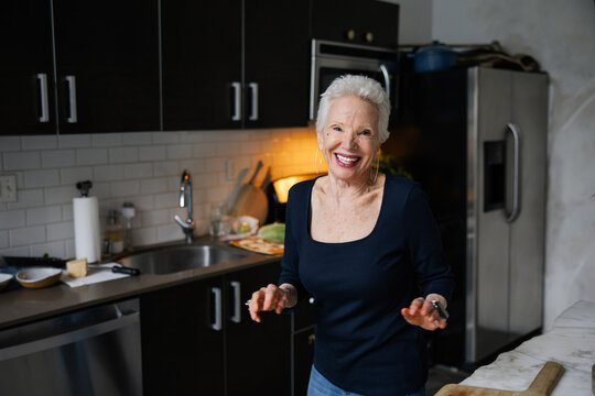 Smiling Elderly Woman in Modern Kitchen with Subtle Lighting