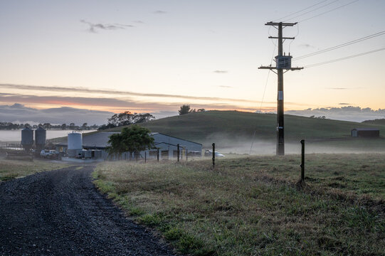 Fog rising over farmland at sunrise.
