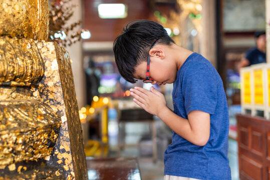 Boy paying respect at Thai Buddhist temple