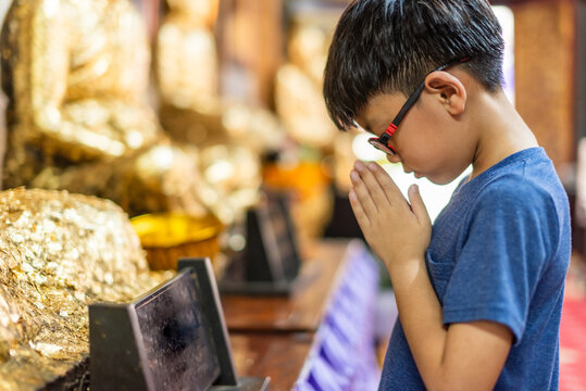 Boy paying respect at Thai Buddhist temple