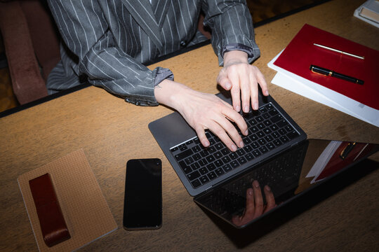 Woman's hands typing on a laptop