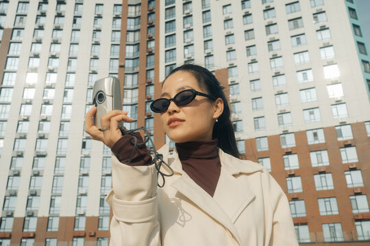 Woman holding a vintage camera in an urban setting