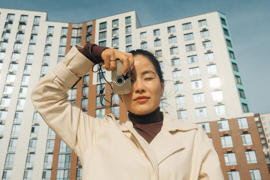 Woman holding a vintage camera in an urban setting