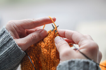 Close-up of hands knitting. Hands of a young woman knitting.