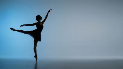 Fototapeta premium Elegant Ballerina Silhouette Performing Side Leg Extension with Blue Gradient Copy Space