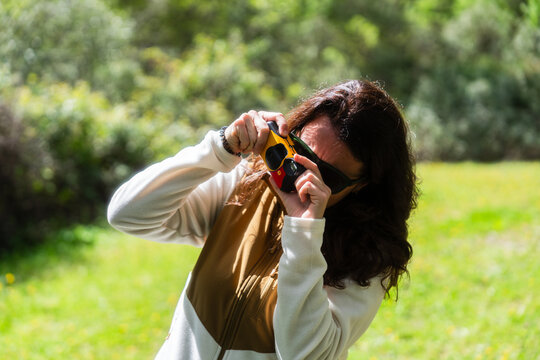 Woman taking pictures with vintage camera in nature
