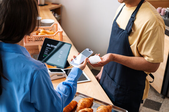 Woman Paying with Phone at Coffee Counter  
