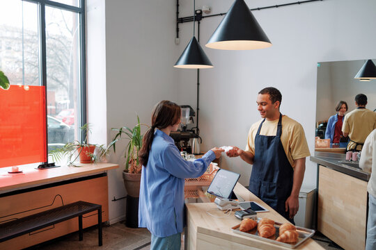Woman Customer Pay Card with Square Reader in Coffee shop