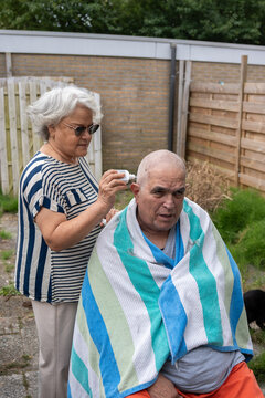 Wife helping to put cream on her husband's face