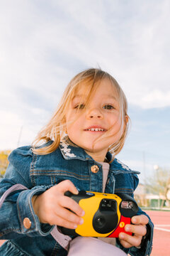  Smiling child holding camera