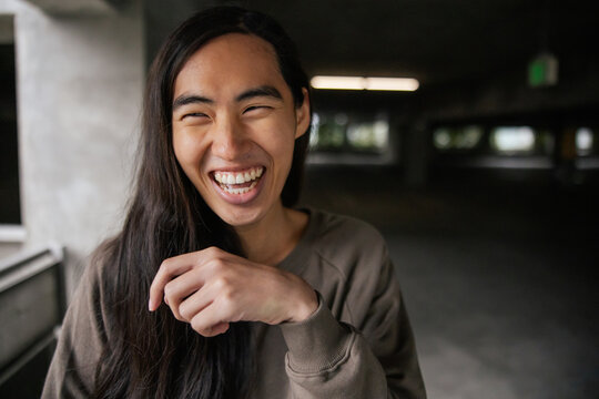 Smiling Person With Long Hair in an Urban Environment