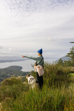 Woman at the summit of a hike with faithful dog