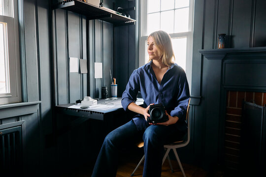 Young woman photographer at her desk 