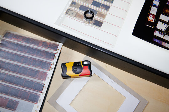Disposable Camera with Negatives and Contact Sheets on Work Surface