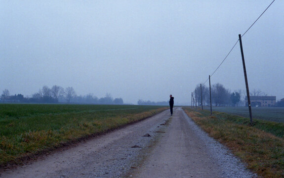 Man standing alone on an empty road track