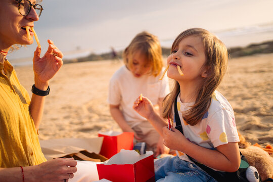 People on beach playing with food and fries